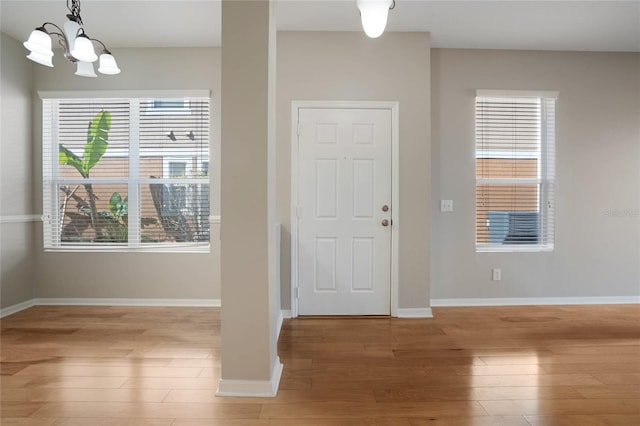 entrance foyer with hardwood / wood-style floors and an inviting chandelier