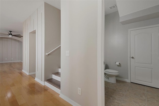 bathroom featuring wood-type flooring, ceiling fan, and toilet