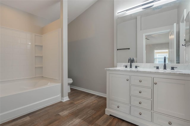 full bathroom with hardwood / wood-style flooring, vanity, toilet, and  shower combination