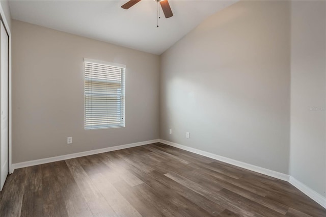 empty room featuring dark hardwood / wood-style flooring, vaulted ceiling, and ceiling fan