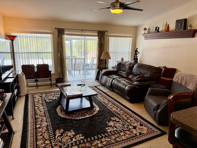 living room with carpet floors, a textured ceiling, and ceiling fan