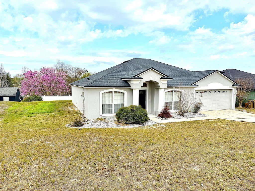 view of front of property featuring a garage and a front yard