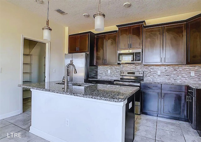 kitchen featuring pendant lighting, dark brown cabinetry, appliances with stainless steel finishes, and a kitchen island with sink