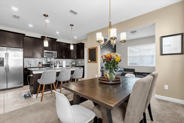 dining room with light colored carpet and an inviting chandelier