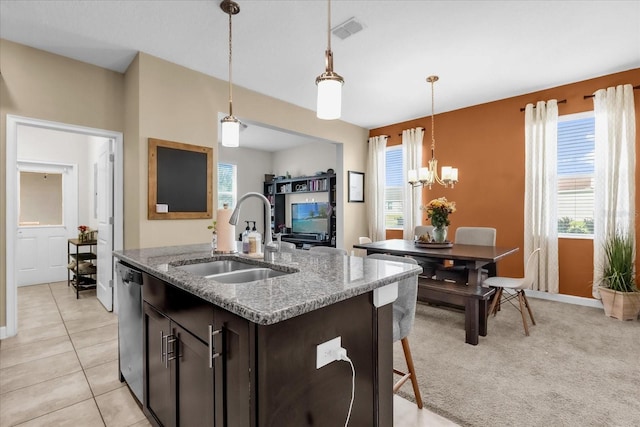 kitchen with dark brown cabinetry, sink, light stone counters, decorative light fixtures, and dishwasher