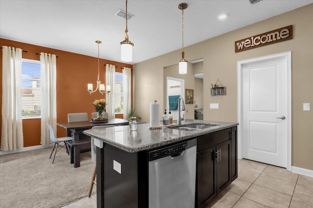 kitchen with sink, decorative light fixtures, stainless steel dishwasher, an island with sink, and light stone countertops