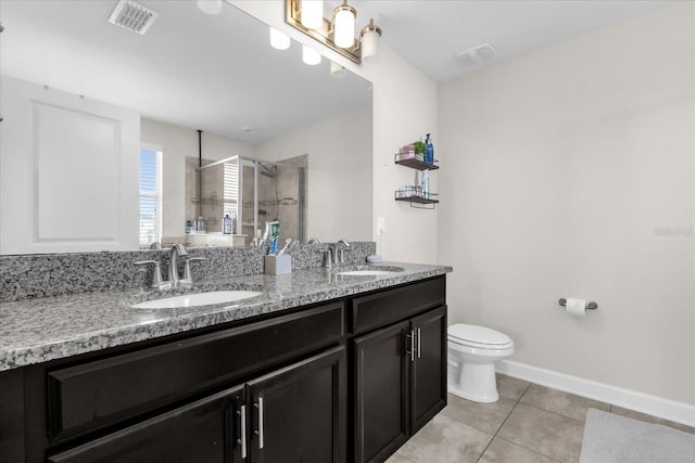 bathroom with tile patterned floors, toilet, a shower with shower door, and vanity