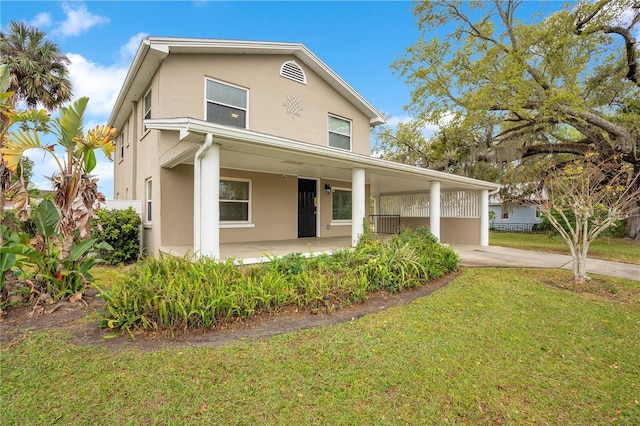 view of front of property featuring a front yard, covered porch, driveway, and stucco siding