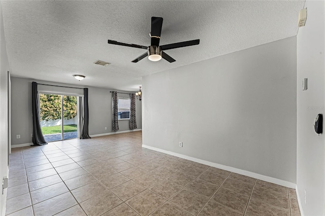 tiled empty room featuring a textured ceiling and ceiling fan