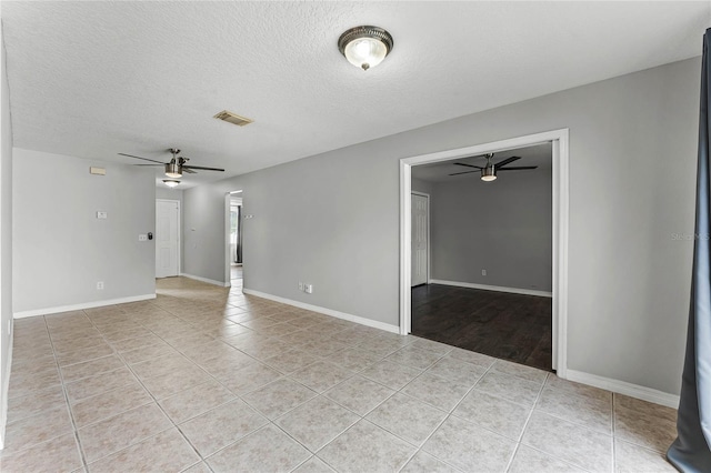 tiled spare room featuring a textured ceiling and ceiling fan