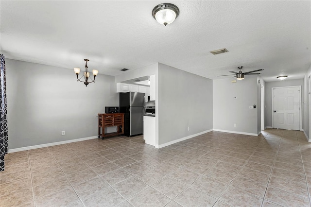 unfurnished living room with ceiling fan with notable chandelier, a textured ceiling, and light tile patterned floors