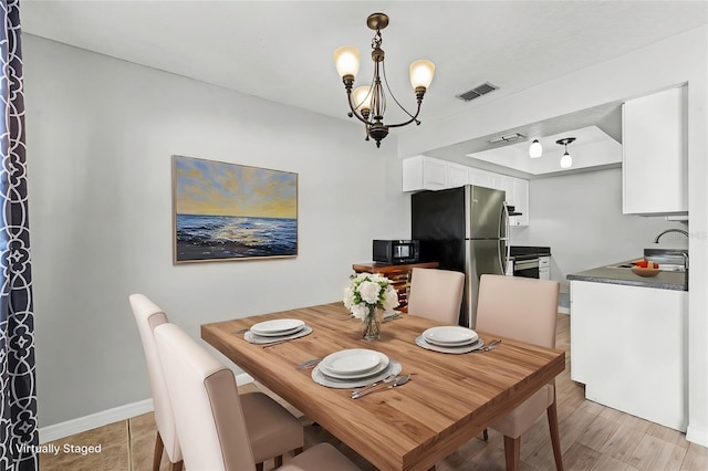 dining space featuring an inviting chandelier and sink