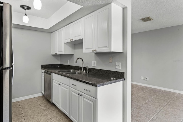 kitchen featuring sink, white cabinetry, hanging light fixtures, a textured ceiling, and appliances with stainless steel finishes