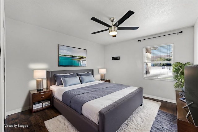 bedroom featuring ceiling fan, dark wood-type flooring, and a textured ceiling