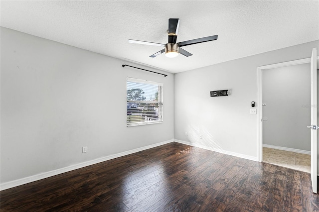 spare room featuring ceiling fan, dark wood-type flooring, and a textured ceiling