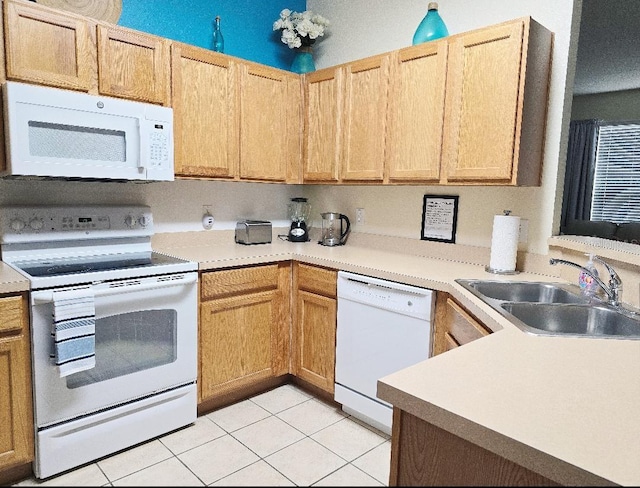 kitchen with light brown cabinetry, sink, white appliances, and light tile patterned floors