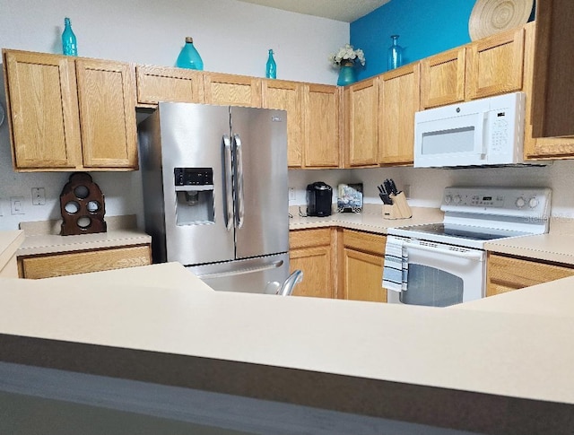 kitchen featuring white appliances and light brown cabinets