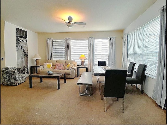 carpeted dining space with ceiling fan