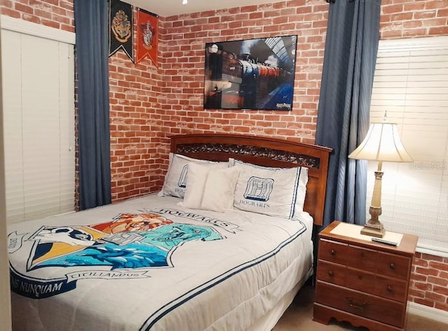 bedroom featuring brick wall