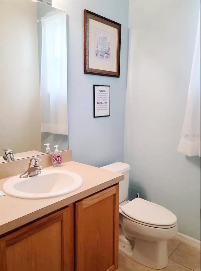 bathroom with vanity, toilet, and tile patterned flooring