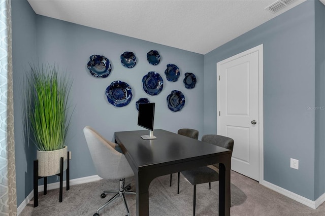 home office with carpet floors and a textured ceiling