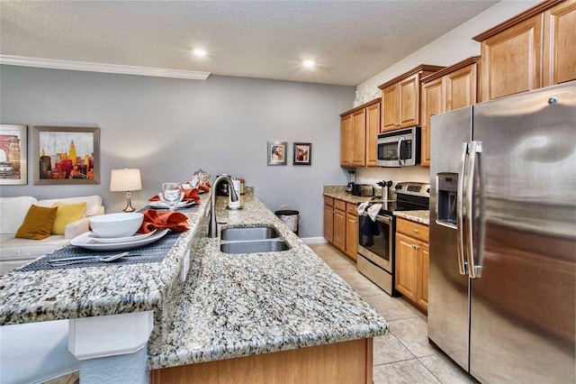 kitchen with light tile patterned flooring, an island with sink, stainless steel appliances, and sink