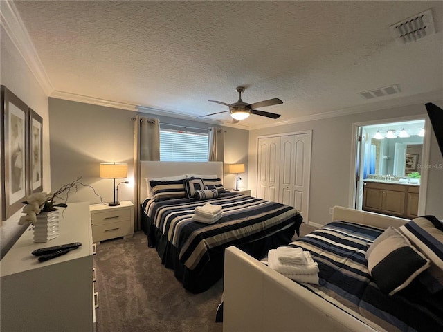 bedroom featuring crown molding, ceiling fan, a textured ceiling, dark carpet, and a closet