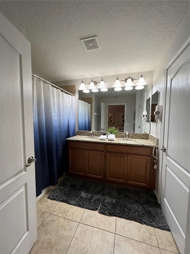 bathroom with vanity, tile patterned flooring, and a textured ceiling