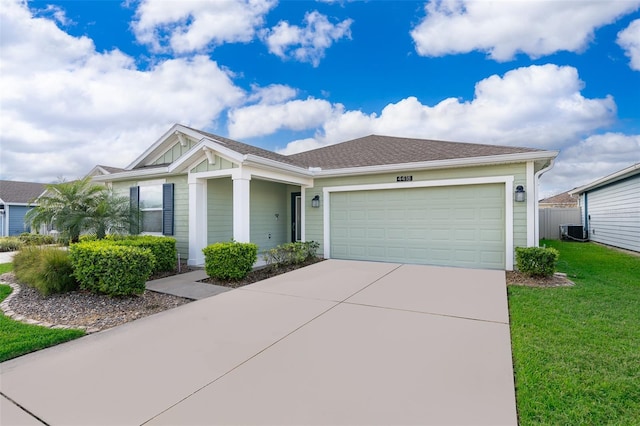 view of front of house featuring a front yard, a garage, and cooling unit