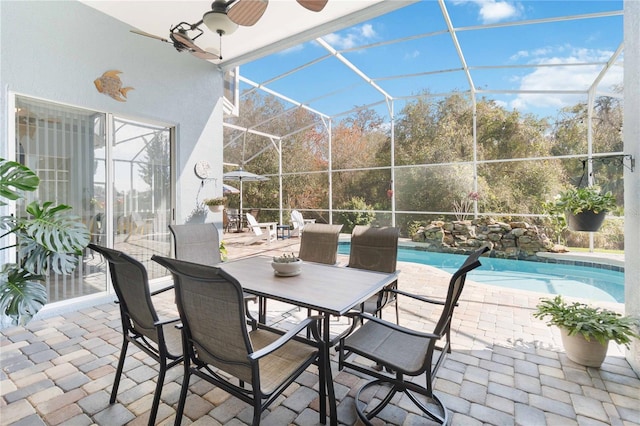 view of patio with a fenced in pool, ceiling fan, and glass enclosure