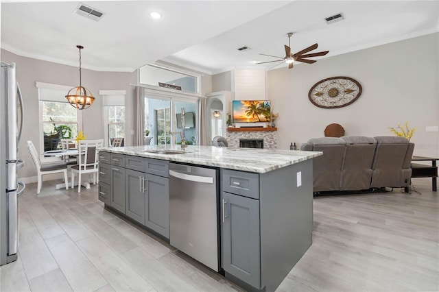 kitchen with gray cabinets, a kitchen island, decorative light fixtures, stainless steel appliances, and light stone countertops