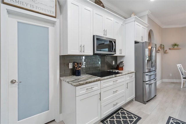 kitchen featuring crown molding, tasteful backsplash, stainless steel appliances, light stone countertops, and white cabinets