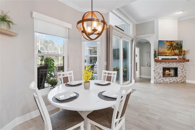 dining area featuring ornamental molding, light hardwood / wood-style flooring, and a notable chandelier