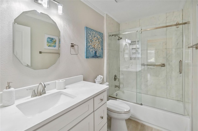 full bathroom featuring enclosed tub / shower combo, vanity, and toilet