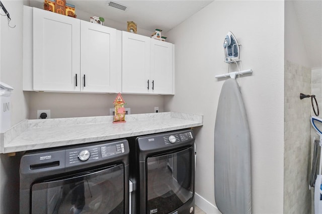 washroom featuring independent washer and dryer and cabinets