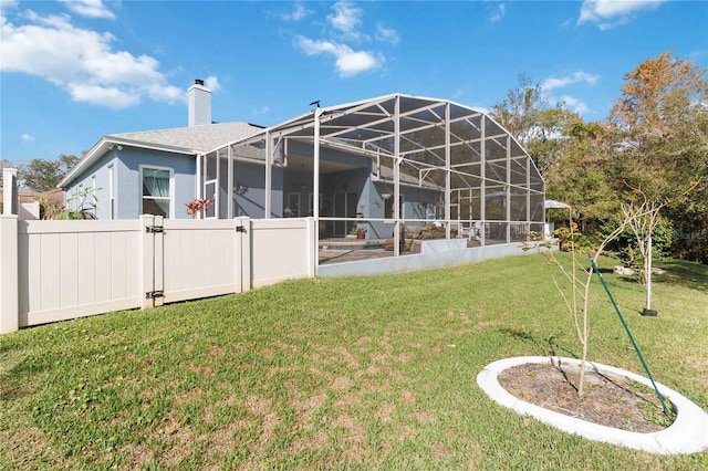 back of house featuring a lanai and a yard