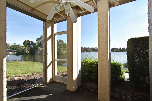 unfurnished sunroom with a water view and ceiling fan