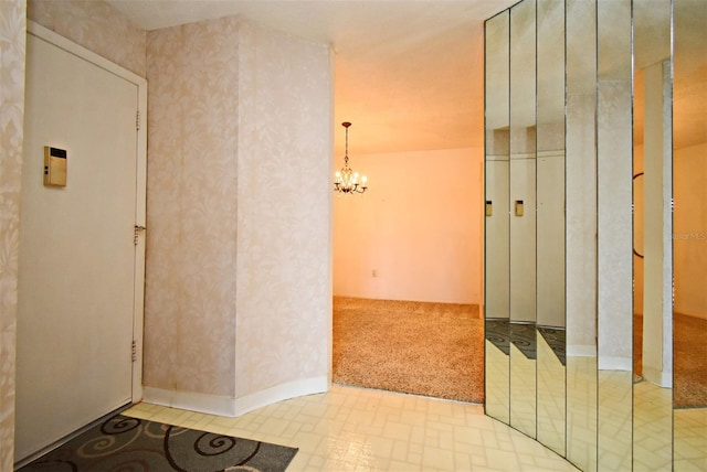 hall featuring light colored carpet and a chandelier