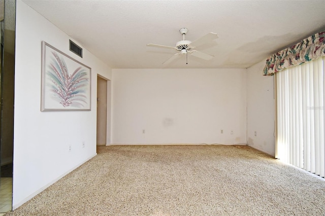 carpeted spare room featuring a textured ceiling and ceiling fan