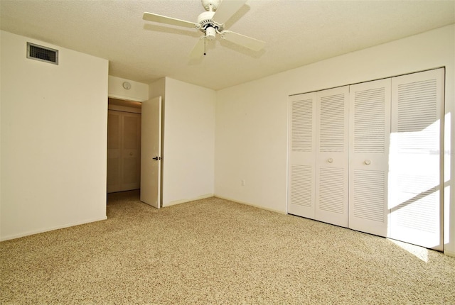 unfurnished bedroom with ceiling fan, light carpet, a closet, and a textured ceiling