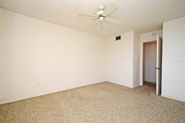 carpeted empty room featuring ceiling fan and a textured ceiling