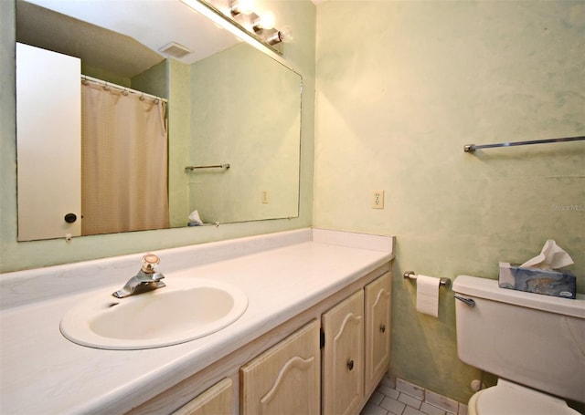 bathroom with vanity, toilet, and visible vents