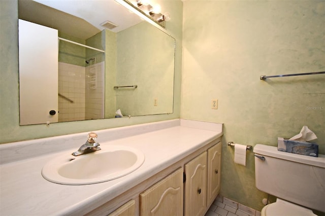 bathroom featuring vanity, toilet, and a shower