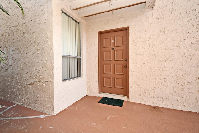 doorway to property featuring stucco siding