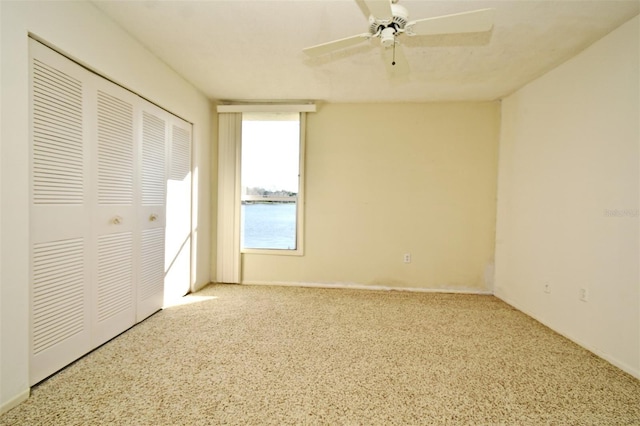 unfurnished bedroom featuring a ceiling fan and a closet