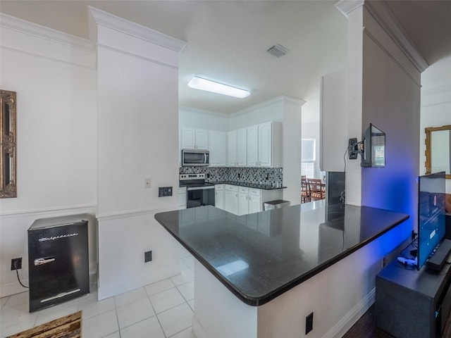 kitchen featuring white cabinetry, tasteful backsplash, light tile patterned floors, kitchen peninsula, and stainless steel appliances