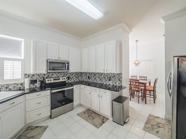 kitchen featuring backsplash, stainless steel appliances, decorative light fixtures, and white cabinets