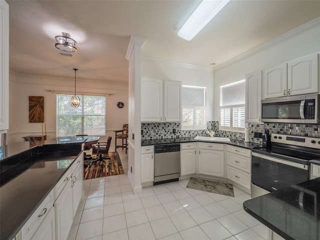 kitchen featuring decorative backsplash, ornamental molding, stainless steel appliances, and white cabinets