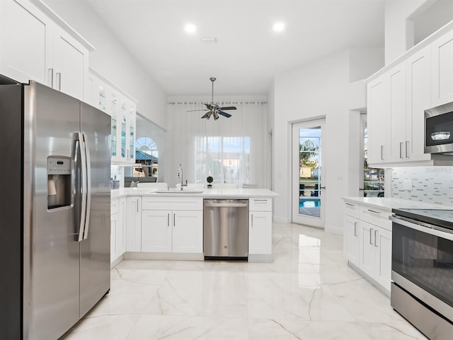 kitchen with white cabinetry, sink, decorative backsplash, ceiling fan, and stainless steel appliances