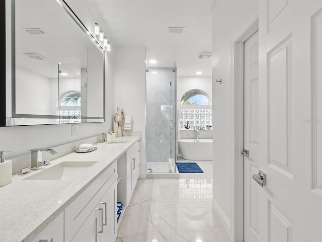 bathroom with vanity and shower with separate bathtub